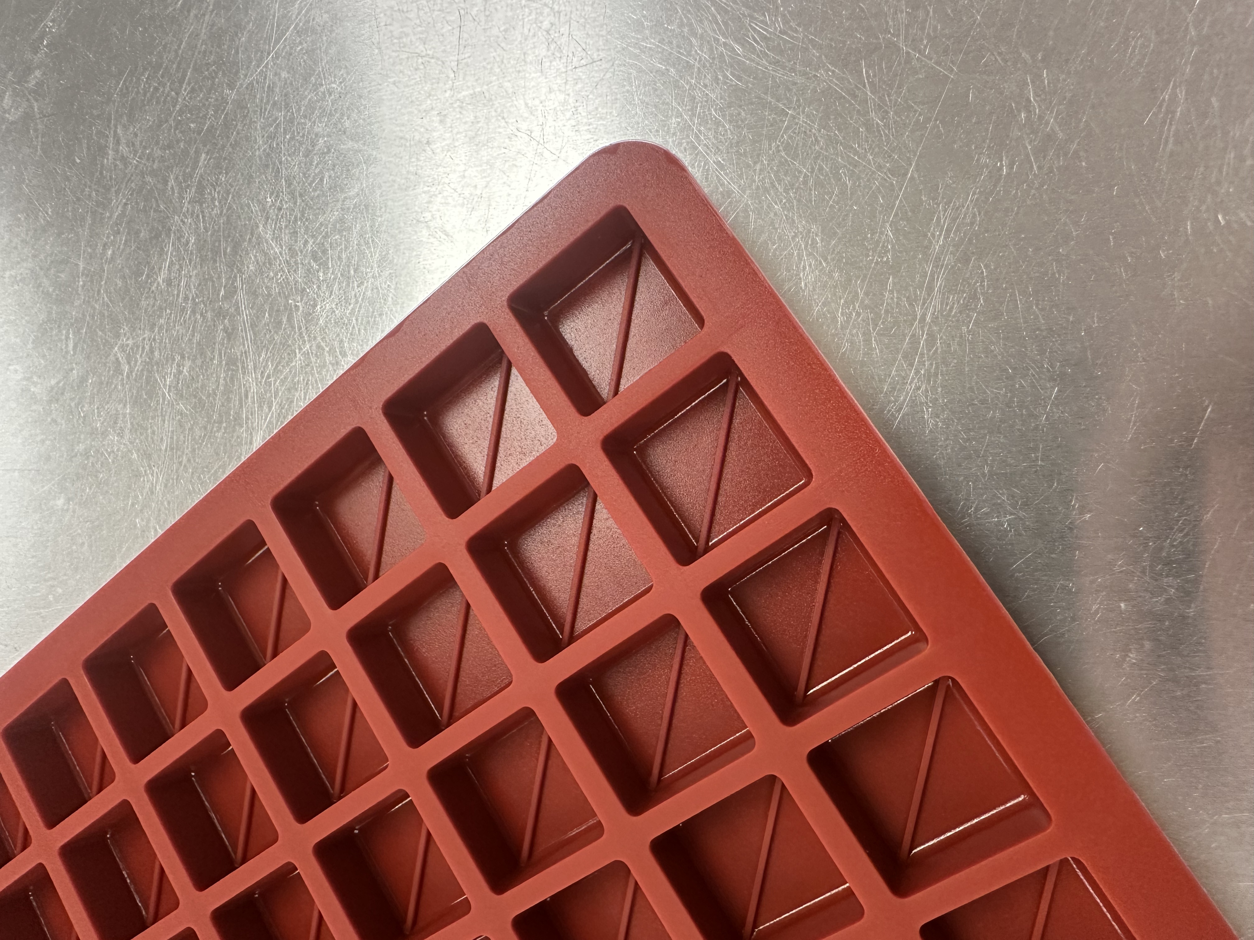 Close-up of square cavities with diagonal split lines on Product 011